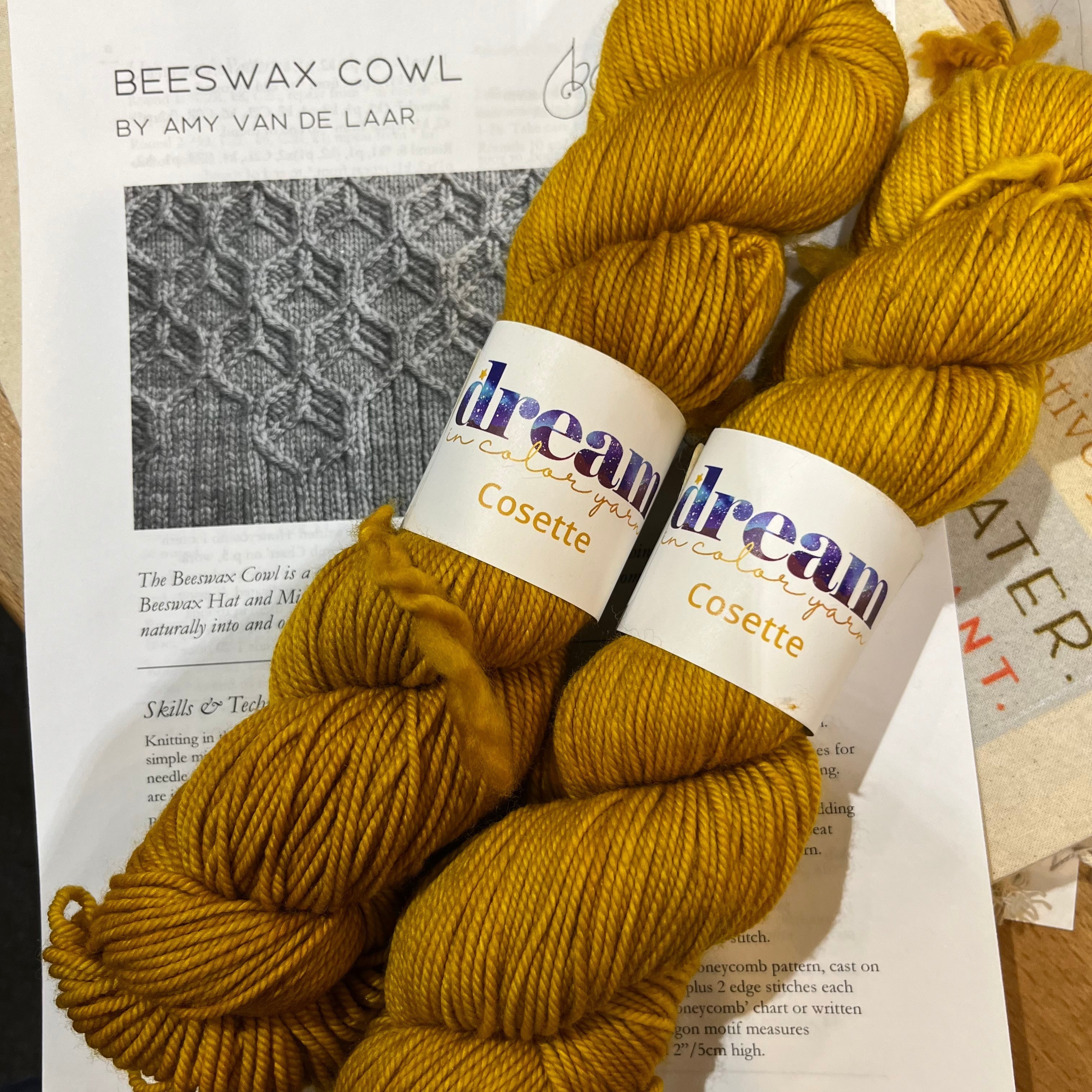 Two skeins of Dream in Color Cosette laying on top of the Beeswax Cowl pattern by Amy Van De Laar