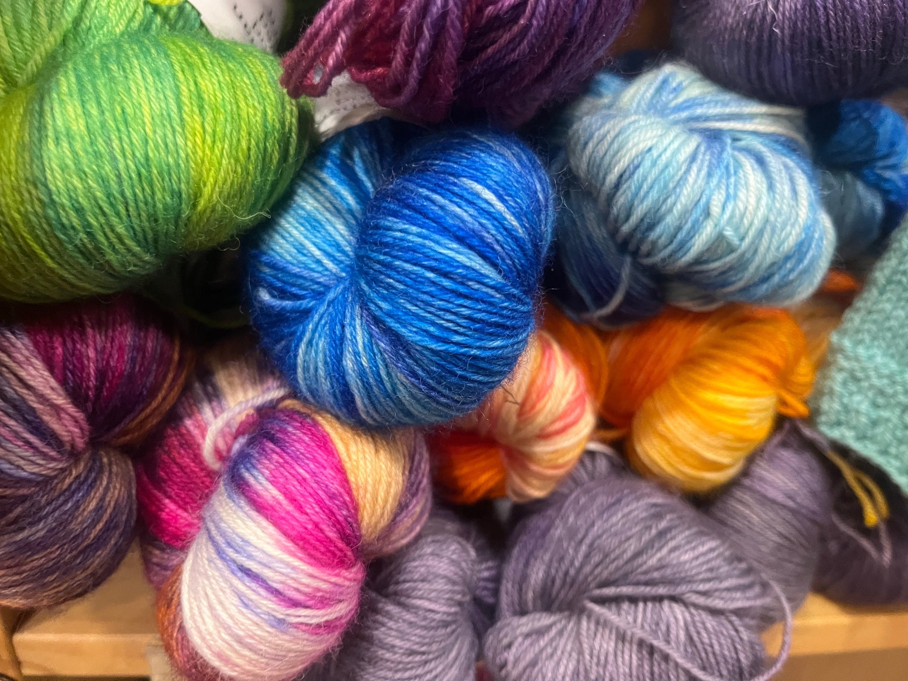 A colorful pile of skeins of fingering weight wool yarn.