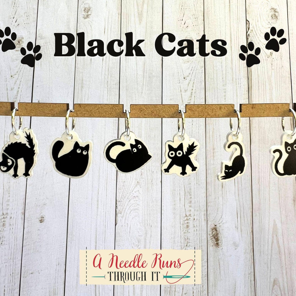 Black cat-shaped stitch markers hanging on a wooden background with 'Black Cats' text above.