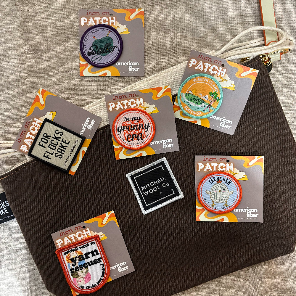 Collection of colorful iron-on patches on a brown fabric background