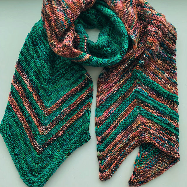 Knitted scarf with green and brown pattern on a white background